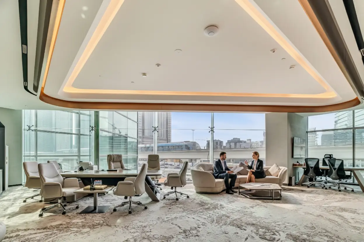 A Zentral CEO cabin with an executive desk, meeting chairs and a sofa lounge area by floor-to-ceiling windows
