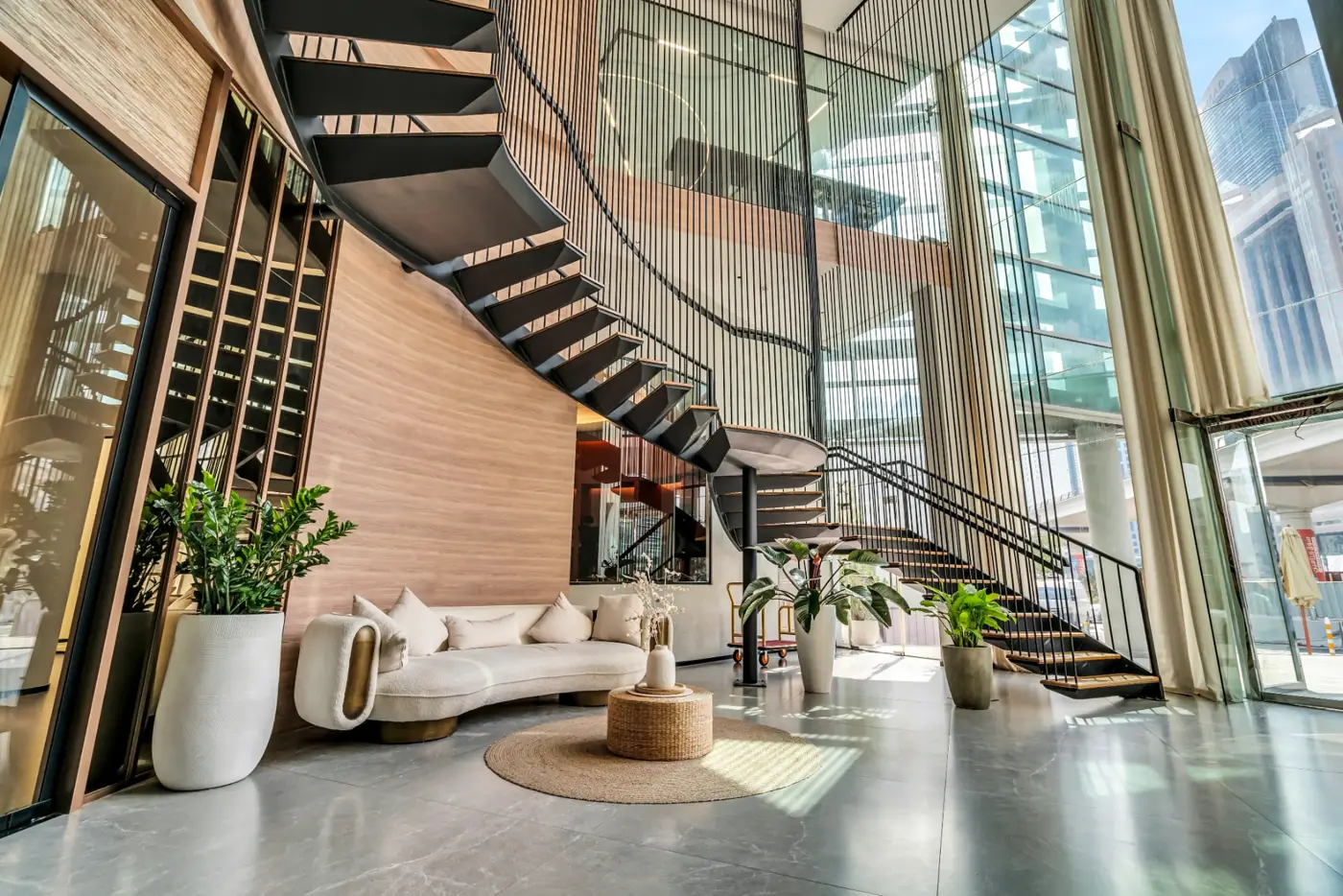 The Zentral lobby with a curved staircase, curved sofa and floor-to-ceiling windows