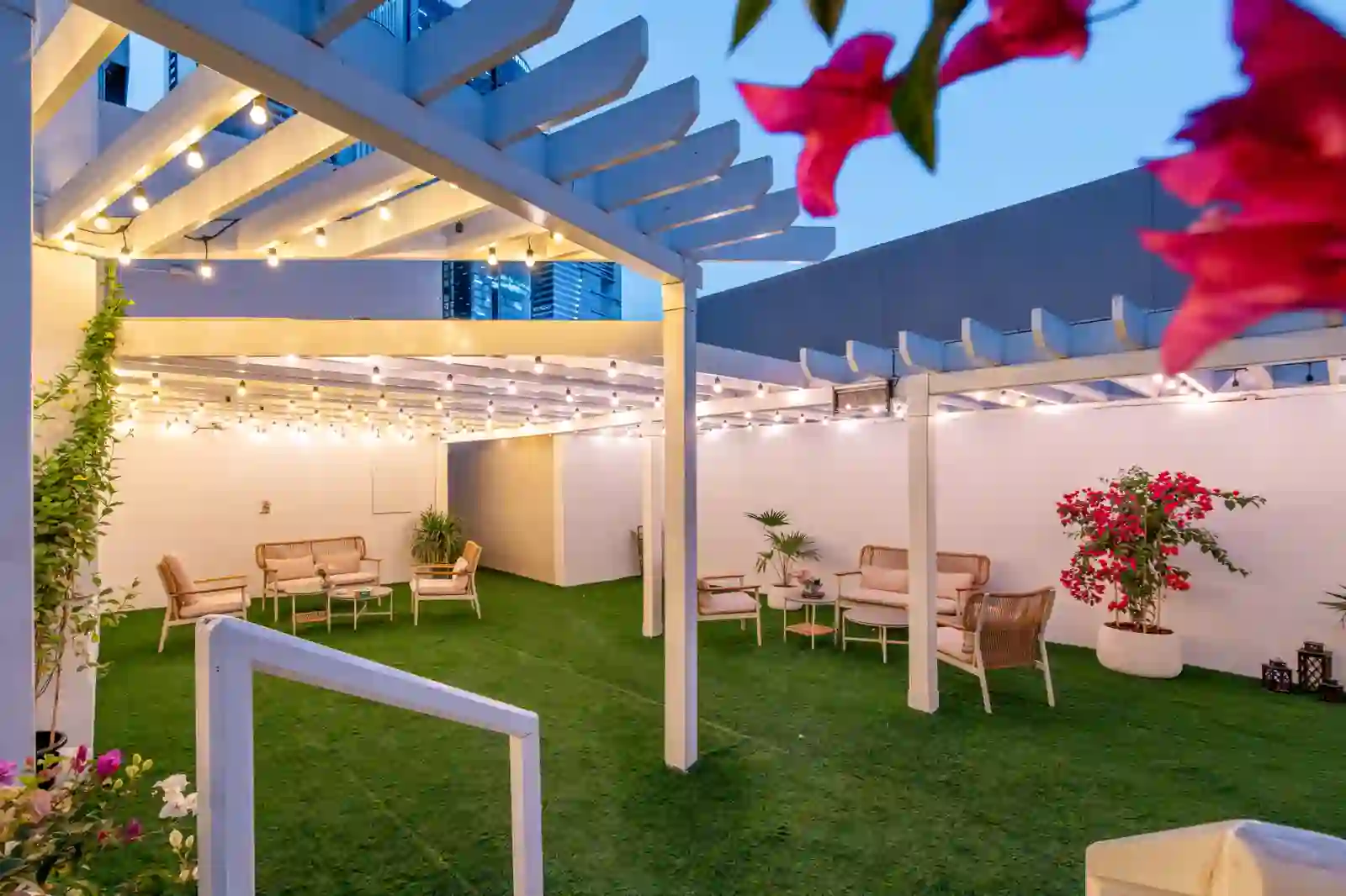 The Zentral outdoor terrace with pergola seating areas and festoon lighting at dusk