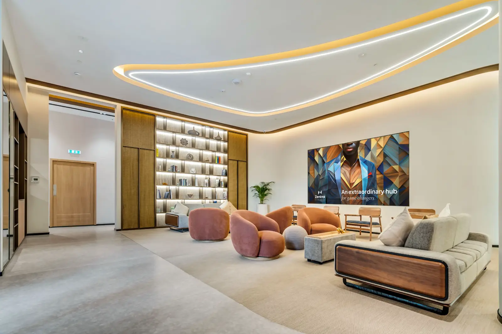 An open Zentral common area with armchairs, shelving and soft ceiling lighting